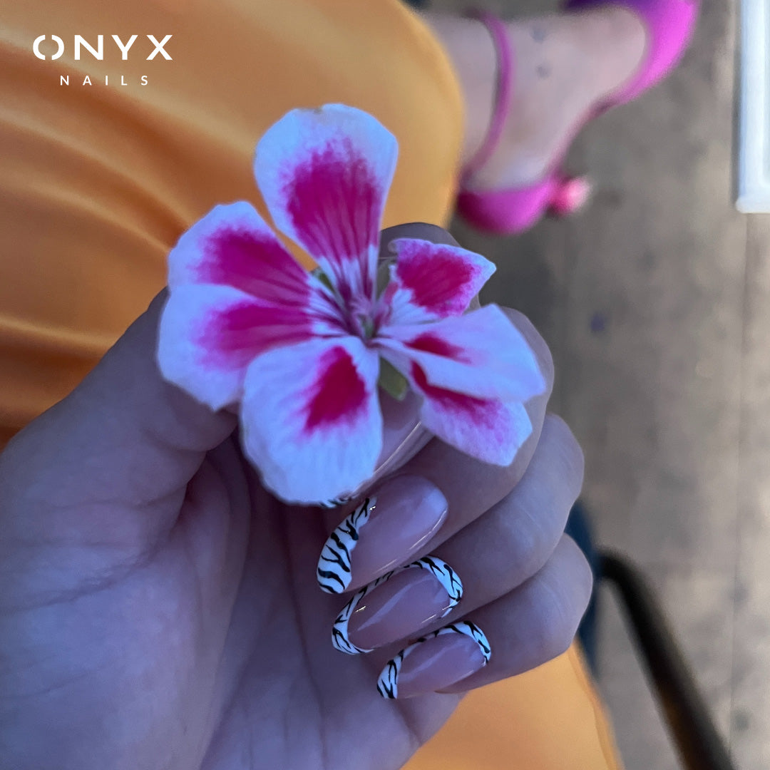 Lilac zebra-print nails with a flower